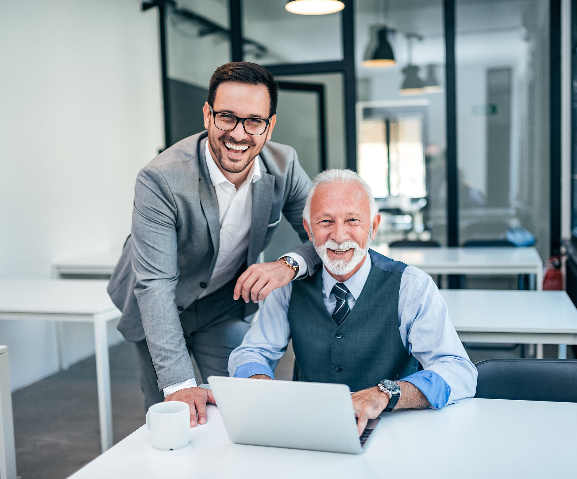 Zwei Männer arbeiten im Büro mit Laptop