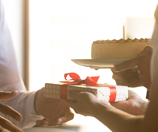 Person erhält weißes Geschenk und Torte