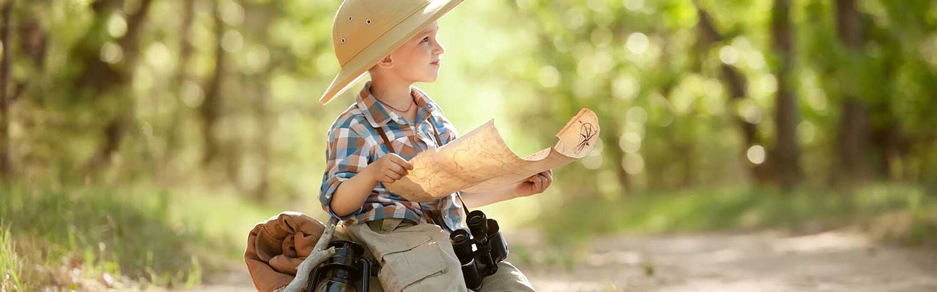 Wanderer kleiner Junge im Wald mit Karte 